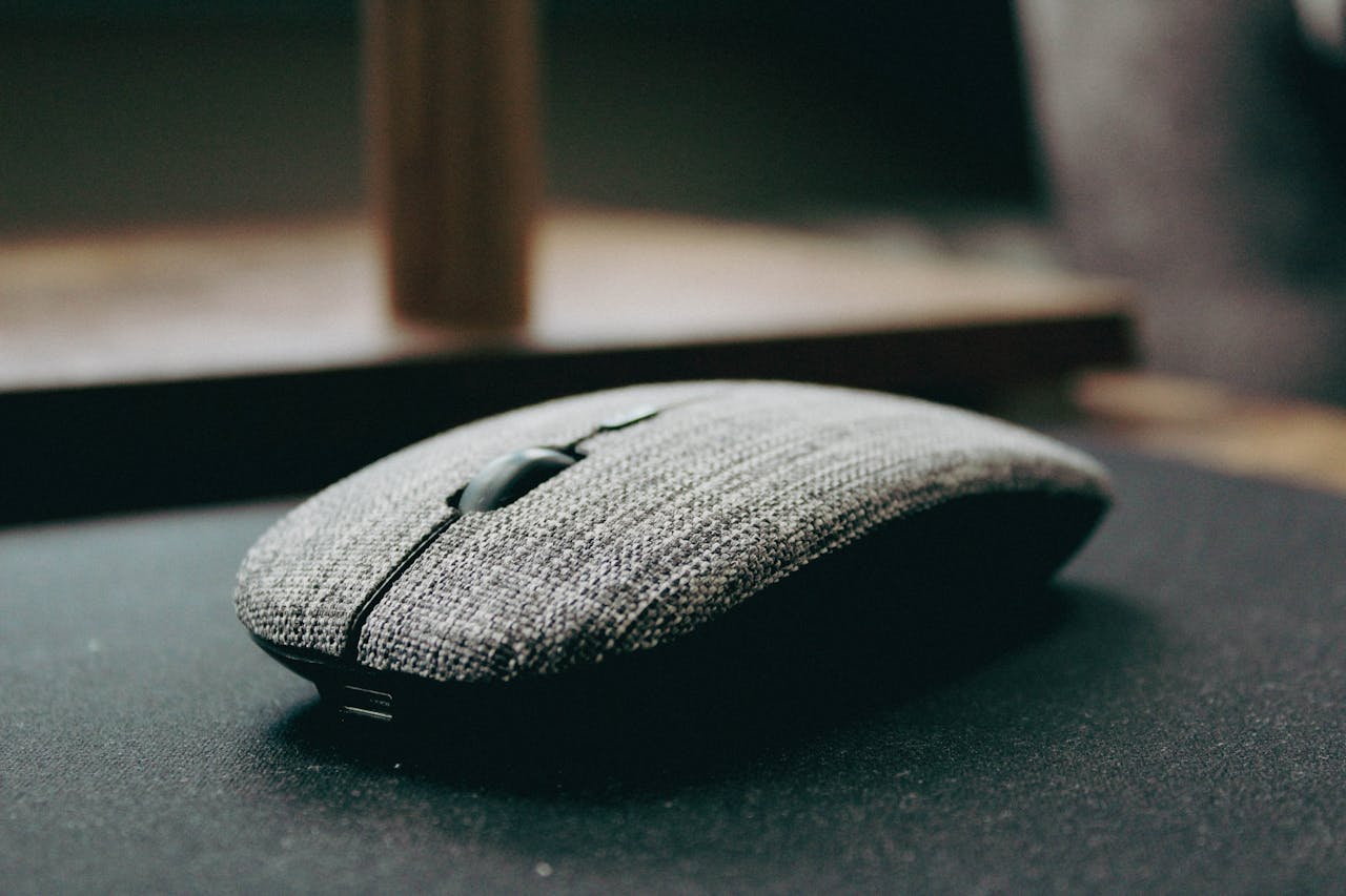 Home Close-up of a stylish wireless computer mouse with a fabric cover, showcasing modern design.